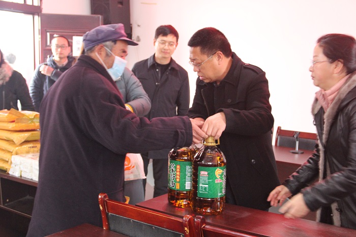 1611287230.jpg 2021年1月21日,九三学社自贡市委慰问大安区新店镇何院村困难群众。图为社市委专职副主委沈涛(右二)发放慰问物资.jpg